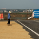 Locals use a road leading to the building’s construction site to dry their grain.